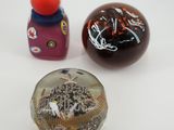 trois petits objets en verre posés sur une surface blanche