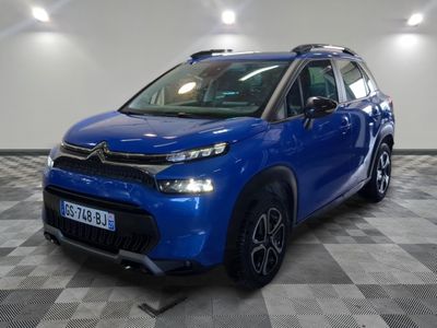 a blue citrole parked on a checkered floor in a garage