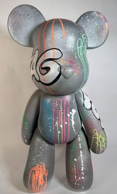 un ours en peluche gris qui a été peint avec de la peinture colorée