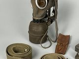 a gas mask, belt, and other items on a white surface