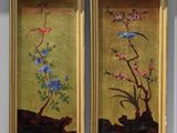two framed paintings of flowers and birds on a wall