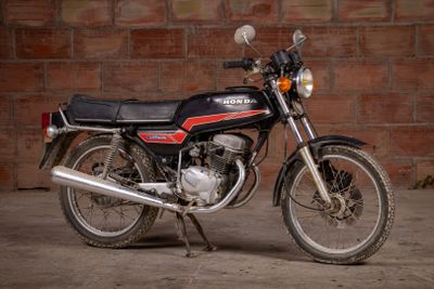a black motorcycle parked in front of a brick wall