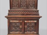 une vieille armoire en bois ornée de sculptures sur le dessus