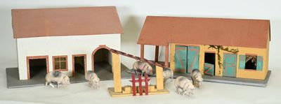 two small toy horses standing in front of a house