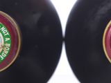 pair of two black bottles with red and green labels on them