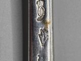 a silver spoon with a design on it on a table