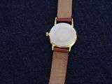 a close up of a watch sitting on top of a blue cloth