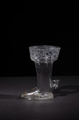 a clear glass vase with a silver handle on a table