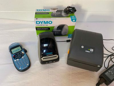 three cell phones sitting next to a printer and a cell phone