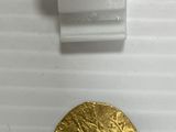 gros plan d'une pièce d'or sur une surface blanche