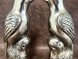 paire de salières et poivrières en forme d'oiseaux en argent sur fond marron