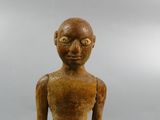 wooden statue of a man with a bald head and no shirt