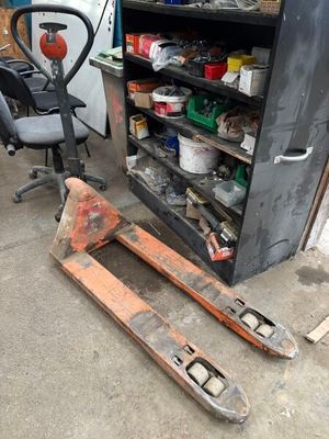 une photo d'un chariot élévateur dans un garage, à côté d'un établi