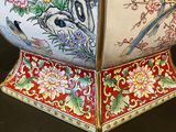 a vase with a bird and flowers on it on a table