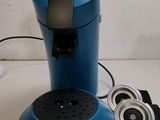 a blue coffee maker sitting on a table next to a charger