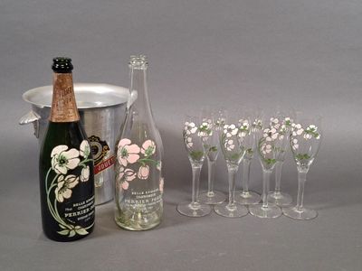 many glasses and a bottle of wine next to a bucket