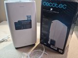 a white air purifier sitting next to a box on a counter