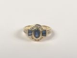 a gold ring with a blue sapphire stone and diamonds