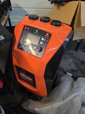 un appareil orange et noir posé sur une table, à côté d'un ordinateur portable
