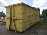 a yellow dumpster sitting in the middle of a field