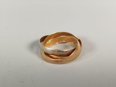 une image représentant une bague en or et en argent posée sur une surface blanche