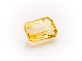 a yellow sapphire stone on a white background