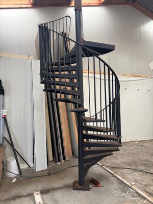 un escalier en colimaçon noir au milieu d'une pièce