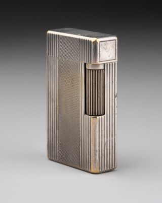 un étui à cigarettes en argent avec un briquet au milieu
