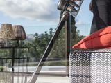 woman using a cordless vacuum cleaner on a patio