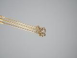 a close up of a gold chain with a heart pendant on it