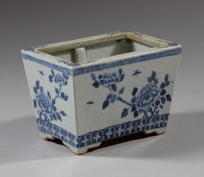 une jardinière bleue et blanche ornée de fleurs