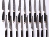 a lot of knives that are lined up on a table