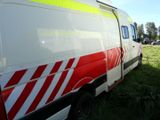 a red and white ambulance parked in the grass