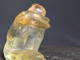 un cristal jaune posé sur une table noire