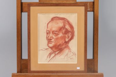 portrait of a man in a suit and tie sitting in front of a wooden easel