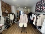 an image of a clothing store with clothes on racks