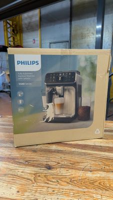 Machine à expresso Philips dans son emballage, posée sur une table en bois