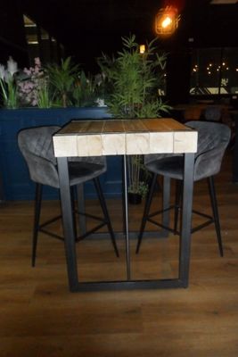 a table with two chairs and a plant in the background