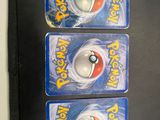 three small plastic pokemon figures on display on a black surface