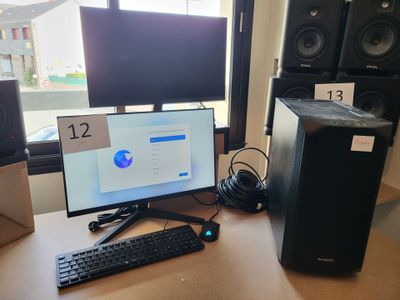 un ordinateur de bureau posé sur un bureau, à côté d'un écran