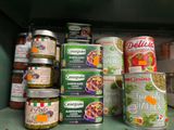 de nombreuses boîtes de conserve posées sur une étagère dans une cuisine