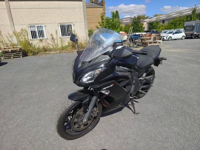 a black motorcycle parked in a parking lot near a building