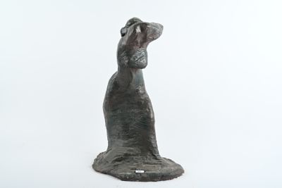 statue d'un chien posée sur une surface blanche, avec un fond blanc