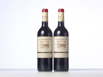 two bottles of red wine sitting next to each other on a table