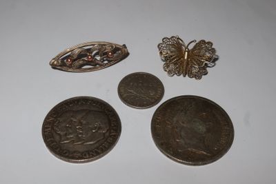 three coins and a broochet are sitting on a table