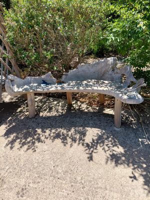 a stone bench sitting in the middle of a garden