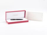 une photo d'un stylo dans une boîte posée sur une surface blanche