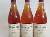 three bottles of wine sitting next to each other on a white surface