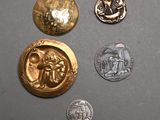 three different types of gold and silver coins on a gray surface