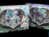 two boxes of pokemon trading cards are shown on a black background
